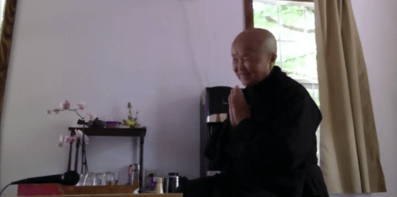 Siser Chan Khong of Plum Village, seated, hands together in a gesture of devotion