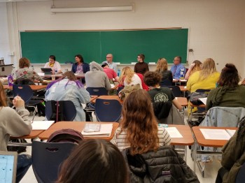 Ray Hemachandra moderating a panel at the University of North Carolina Asheville, with autistic adults and autism/disability professionals talking about the value of disabled lives prior to the 2018 Disability Day of Mourning.