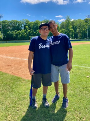 Two young men standing together on the field in "Braves" T-shirts after baseball practice